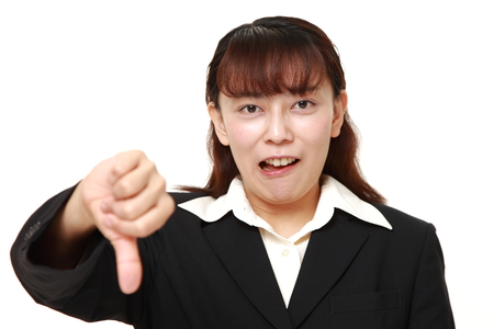 asian businesswoman with thumbs down gestureの写真素材