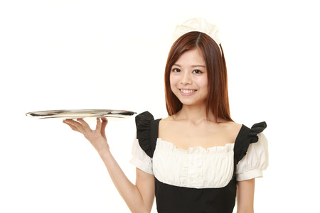 young Japanese woman wearing french maid costume with trayの写真素材