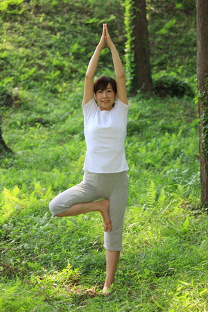 Japanese woman doing yoga tree poseの写真素材