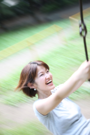 young woman rides on the swingの写真素材