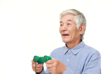 senior Japanese man enjoying a video gameの写真素材