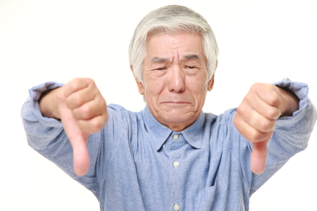 senior Japanese man with thumbs down gestureの写真素材