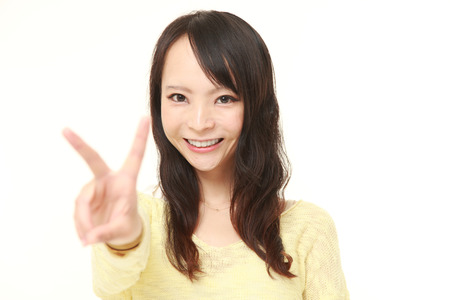 young Japanese woman showing a victory signの写真素材