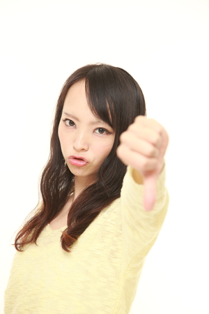 woman with thumbs down gestureの写真素材