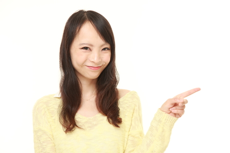 young Japanese businesswoman presenting and showing somethingの写真素材