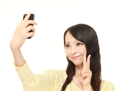 Japanese woman takes a selfieの写真素材