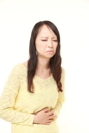 young Japanese woman suffers from stomachacheの写真素材