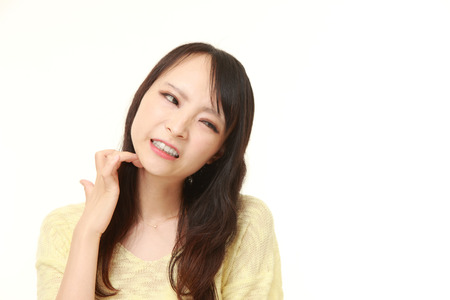 Japanese woman scratching her neckの写真素材