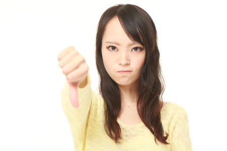 woman with thumbs down gestureの写真素材