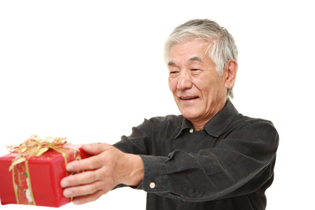 senior Japanese man offering a giftの写真素材