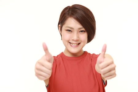 young Japanese woman with thumbs up gestureの写真素材