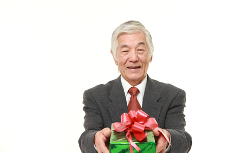 senior Japanese businessman offering a giftの写真素材