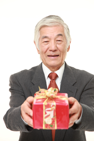 senior Japanese businessman offering a giftの写真素材