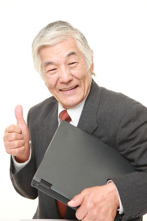 senior Japanese  businessman carrying laptop computerの写真素材