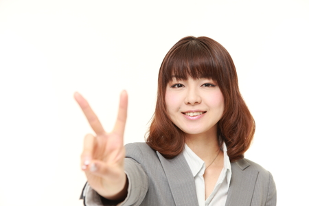 young Japanese Businesswoman showing a victory signの写真素材