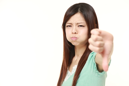 young Japanese woman with thumbs down gestureの写真素材