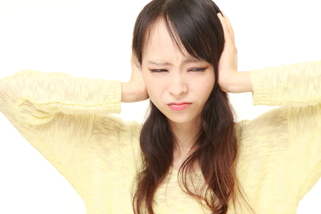 Young Japanese woman suffers from noiseの写真素材
