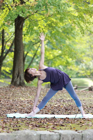 Japanese woman doing yoga triangle poseの写真素材