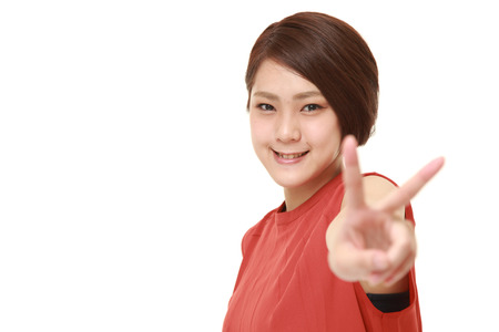 young Japanese woman showing a victory signの写真素材