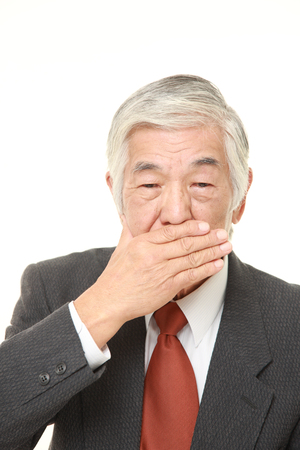 senior Japanese businessman making the speak no evil gestureの写真素材