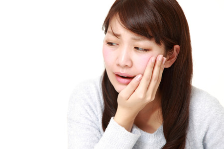 young Japanese woman suffers from toothacheの写真素材