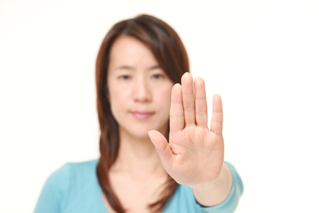 middle aged Japanese woman making stop gesture