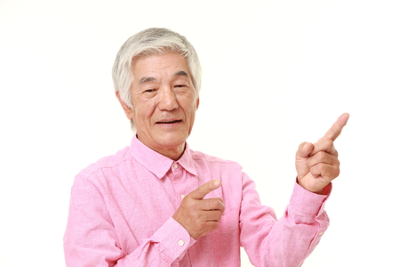 senior Japanese man presenting and showing somethingの写真素材