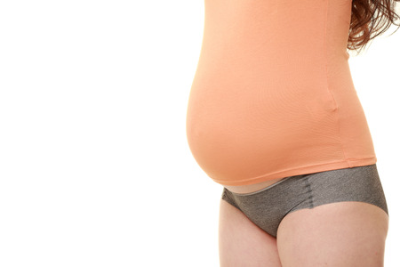 pregnant woman wearing orange shirt isolated on white backgroundの写真素材