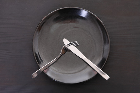 black dish on the black table with cutlery meaning DO NOT LIKEの写真素材