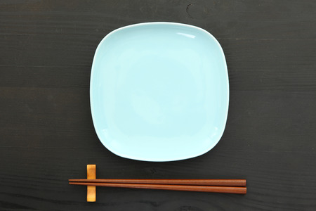 empty blue dish with chopsticks on the black table