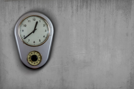 old vintage clock hanging on a concrete wallの写真素材