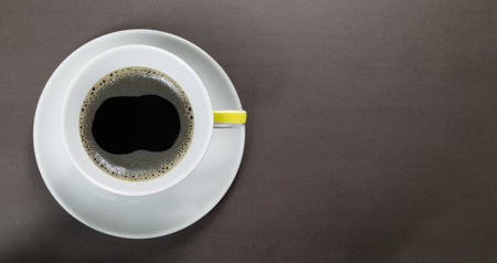 Hot coffee with bubbles on a dark stone table. Top view with copy space.の写真素材