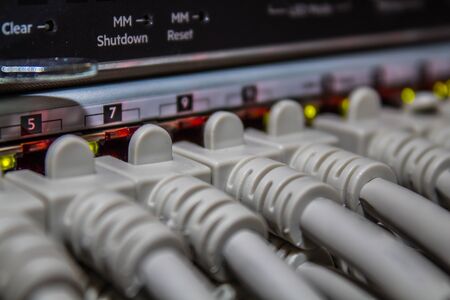 Network cables connected to a switch or hub. Close up on the ports and led.の写真素材