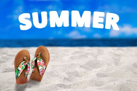 Summer vacation concept. Flipflops on a sandy ocean beach. With the text summer.の写真素材