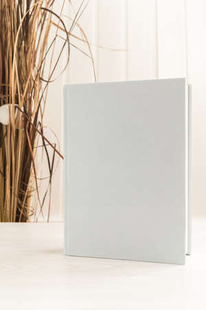 Blank white book cover on a table.の写真素材
