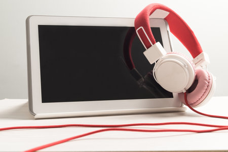 Headphones with white tablet notebook on a table.の写真素材