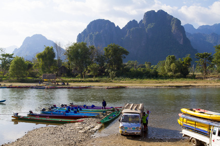 VANG VIENG, LAO P D R Unidentified men are preparing completion for tourists to take long-tailed boat tour in Song River in Vang Vieng, Lao P D Rのeditorial素材