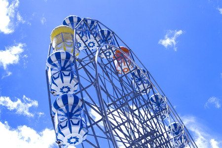 Giant ferris wheel against blue sky and white cloudのeditorial素材