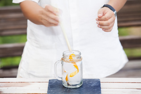 Bartender is adding ingredient in shaker at bar counter