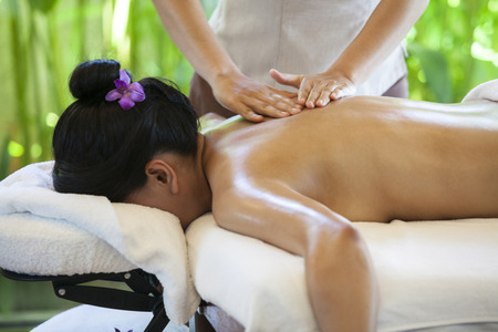woman receiving back massage at spa. Female having relaxing massage on her back in spa salon.の写真素材