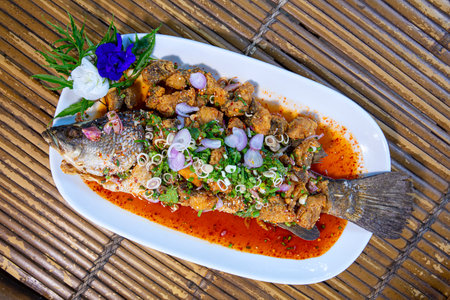 Thai dishes made from fried snapper topped with mixed salad from fresh herb and spices such as...