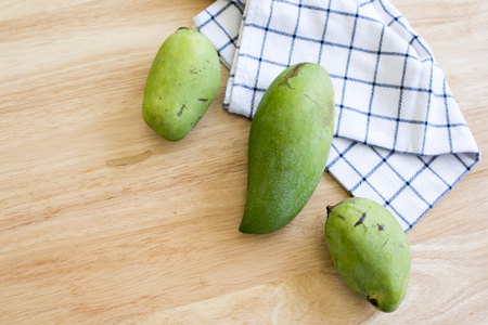 Whole Green Mango on a wooden table.の写真素材