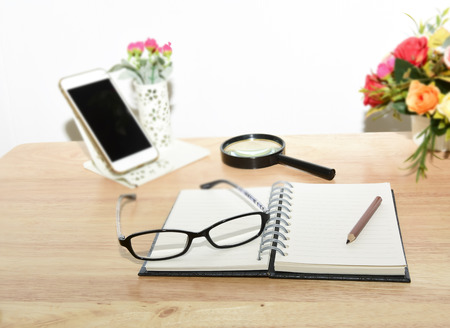 Business planning with copy space and office supplies.Have Blurry mobile and magnifying glasses ,mobile and glasses on wood background as props.の写真素材