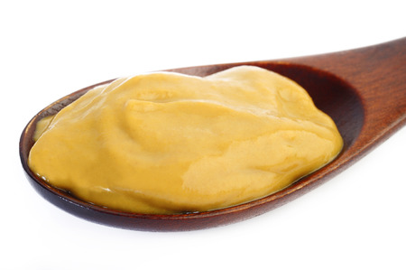 Mustard sauce in wooden spoonの写真素材
