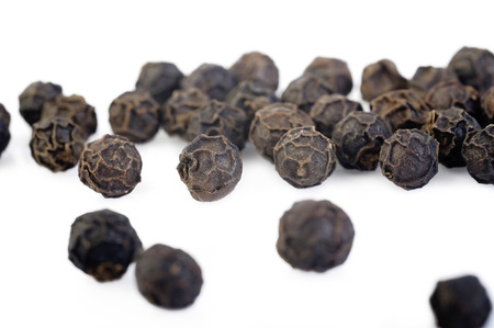 Black pepper seeds on white background
