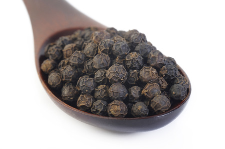 Black pepper seeds in wooden spoonの写真素材