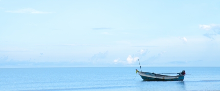 old fishing boat resting on the beach of Thailand, at sunrise.の写真素材