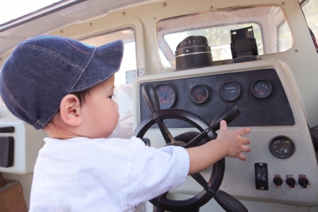 Little Boy Steering the Motor Boatの写真素材