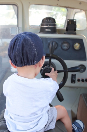 Little Boy Steering the Motor Boatの写真素材
