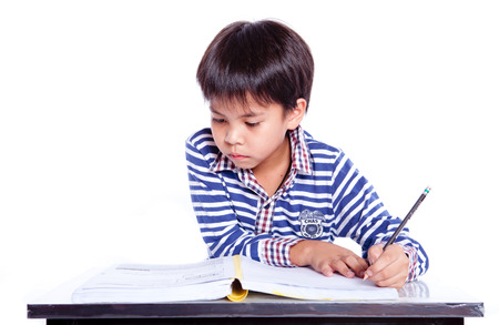 A young boy  in his homework or maybe writing a letter.の写真素材